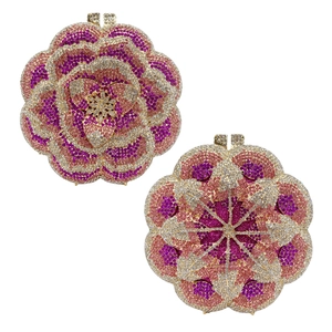 Detail of rose-shaped metal clutch with pink and purple rhinestones and crystal clasp