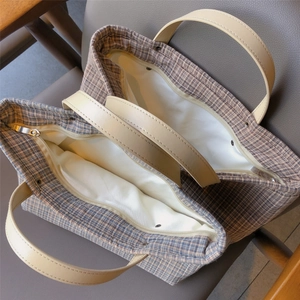 Top view of spacious tote interior with plaid canvas texture and zipper closure