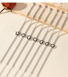 Detail of S925 silver tennis bracelets with black enamel and various geometric charms