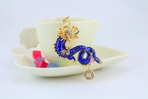 Detailed view of blue enamel Chinese dragon pendant with golden accents and crystal charms
