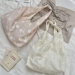 Detailed view of floral embroidery on light pink and cream white cotton linen tote bags