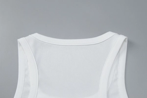 Gros plan d'un débardeur blanc en maille côtelée avec encolure ronde et texture fine