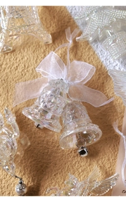 Macro shot of acrylic Christmas bell ornament with ribbon and iridescent crystal finish