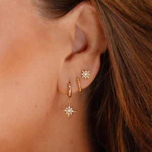 Detail view of gold S925 sterling silver star studs and bead hoop earrings with opals