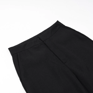 Detailed close-up of black high-waisted trousers with precise stitching and side pockets
