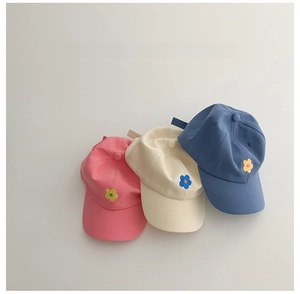 Détail de broderie de fleurs colorées sur casquettes de baseball en coton pour enfants