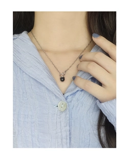 Detail shot of a black agate bead pendant on a sterling silver chain worn by a model