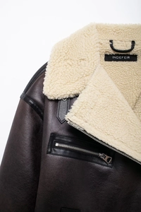Close-up of deep brown leather jacket with cream faux fur lining and metal zipper detail