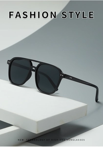 Detail of black double-bridge square sunglasses with silver rivet accents on high-end frame