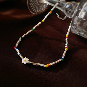 Détail du collier choker avec perles colorées, cubes argentés et charm de marguerite