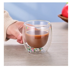 Close-up of a double-walled glass cup with colorful candy flakes and coffee inside