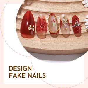 Red and nude press-on nails with golden bows, 3D textures, and crystal embellishments