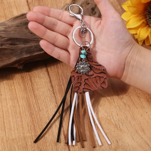 Western boho keychain with sunflower, turquoise and leather fringe tassels held in hand