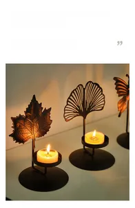 Detail of Nordic black metal tea light holders with maple leaf and ginkgo shadows