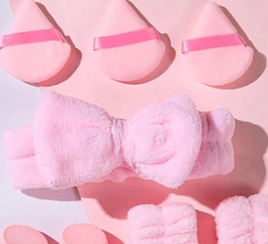 Pink flannel beauty set with bow headband, wristbands, and soft makeup sponges