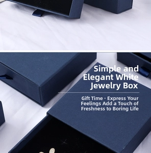 Detail view of navy blue sliding jewelry gift box with black velvet lining and pull ribbon