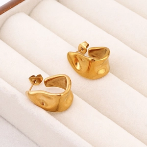 Macro view of irregular molten 18K gold plated stainless steel wave earrings on display