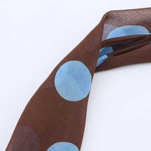 Close-up detail of brown fabric with large blue polka dots pattern showing smooth texture