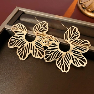 Detail der goldenen Vintage-Ohrringe auf einer hochwertigen braunen Schmuckbox