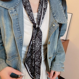 Detail of a black paisley silk scarf necklace with a retro ethnic floral pattern