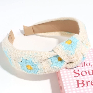 Detailed close-up of ivory crochet headband featuring light blue embroidered flowers