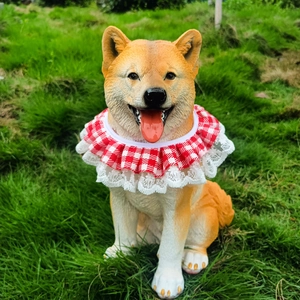 Detail of red and white plaid pet bib with lace trim worn by a Shiba Inu on grass