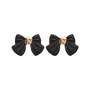 Elegant matte black bow earrings with gold metallic center knot on white background