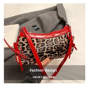 Detail of leopard print suede bag with red patent leather trim and bow drawstring