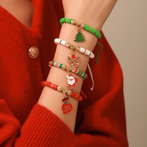 Détail d'un ensemble de bracelets de Noël avec breloques élan et Père Noël au poignet