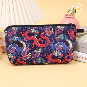 Detail of fabric cosmetic bag with dragon pattern, black zipper and side handle loop