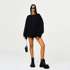 Oversized black cotton zip hoodie with iconic white cross design in a minimalist studio setting