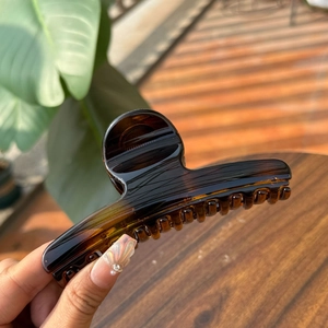 Detail showing amber tortoiseshell claw clip texture and transparency in sunlight