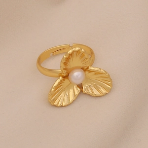 Close-up of golden shell-inspired ring featuring a central pearl and open band design