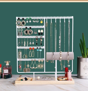 Detailed jewelry organizer with white metal frame, wooden base and partitioned storage