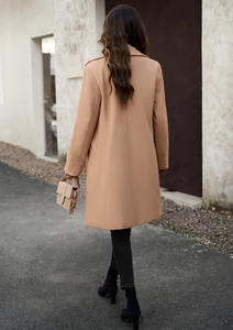 Rear view of a camel wool coat with a minimalist long-line cut in a street-style setting