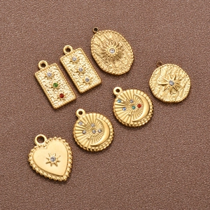 Detail of 18K gold-plated stainless steel charms with celestial engravings and colorful crystals