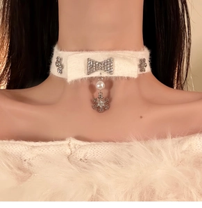 Detail of knit bow choker with snowflake pendant and pearls on model neck