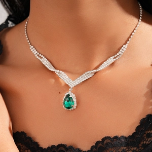 Macro detail of luxury water-drop green emerald pendant with rhinestones on V-chain