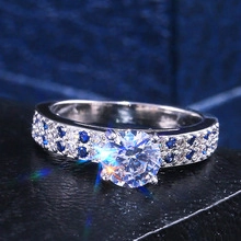 Macro view of vintage round-cut zircon ring with alternating blue and white side stones