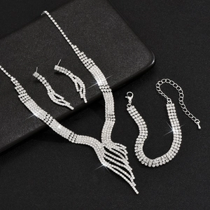 Detailed view of silver necklace, bracelet and earrings set with sparkling rhinestones