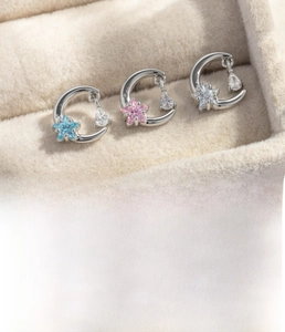 Detail of silver crescent moon and star stud earrings with colorful zircon stones