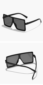 Detail view of square oversized kids sunglasses with black frame and grey lenses
