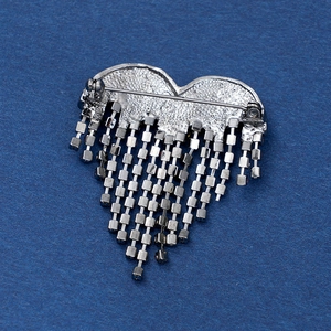 Silver heart brooch with elegant rhinestone tassels on a textured blue background