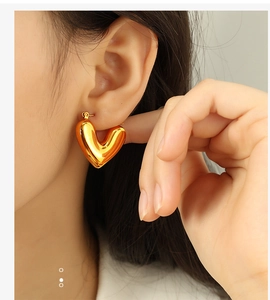 Gros plan sur la boucle d'oreille créole en forme de cœur doré sur un mannequin