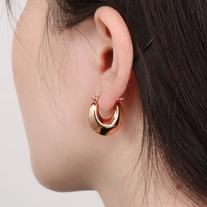 Close-up of rose gold hollow U-shaped geometric earrings on a model for daily wear