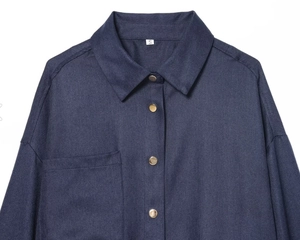 Détail de la veste en sergé bleu marine avec quatre boutons-pression en métal doré