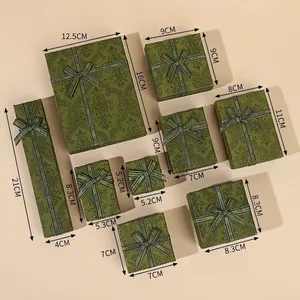 Vintage green jewelry gift boxes with gold leaf patterns and decorative Best Wishes ribbons