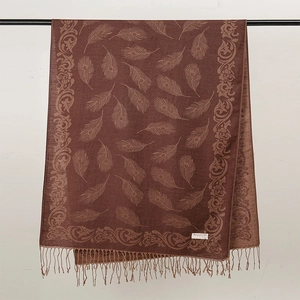 Dettaglio di scialle pashmina marrone con motivi a piuma di pavone e nappine frangiate vintage