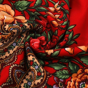Macro detail of red ethnic floral paisley silk scarf fabric with herringbone texture