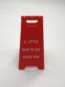 Detail of red plastic A-frame sign featuring white I LOVE YOU lettering for cat owners